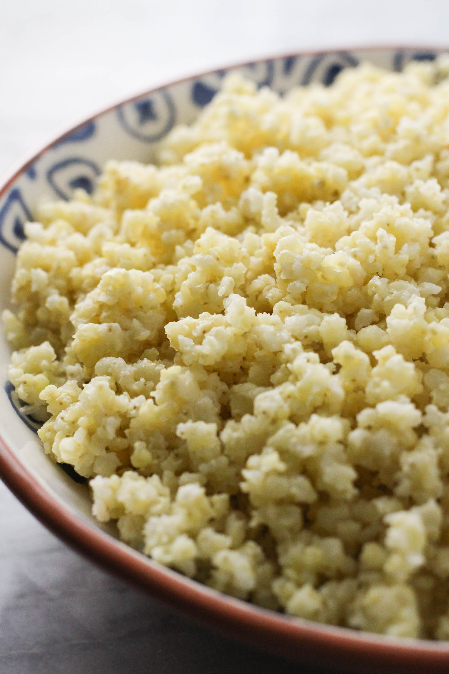 Side view close up shot of cooked millet in a bowl.