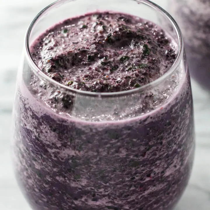 Close up shot of the blueberry kale smoothie in a glass.