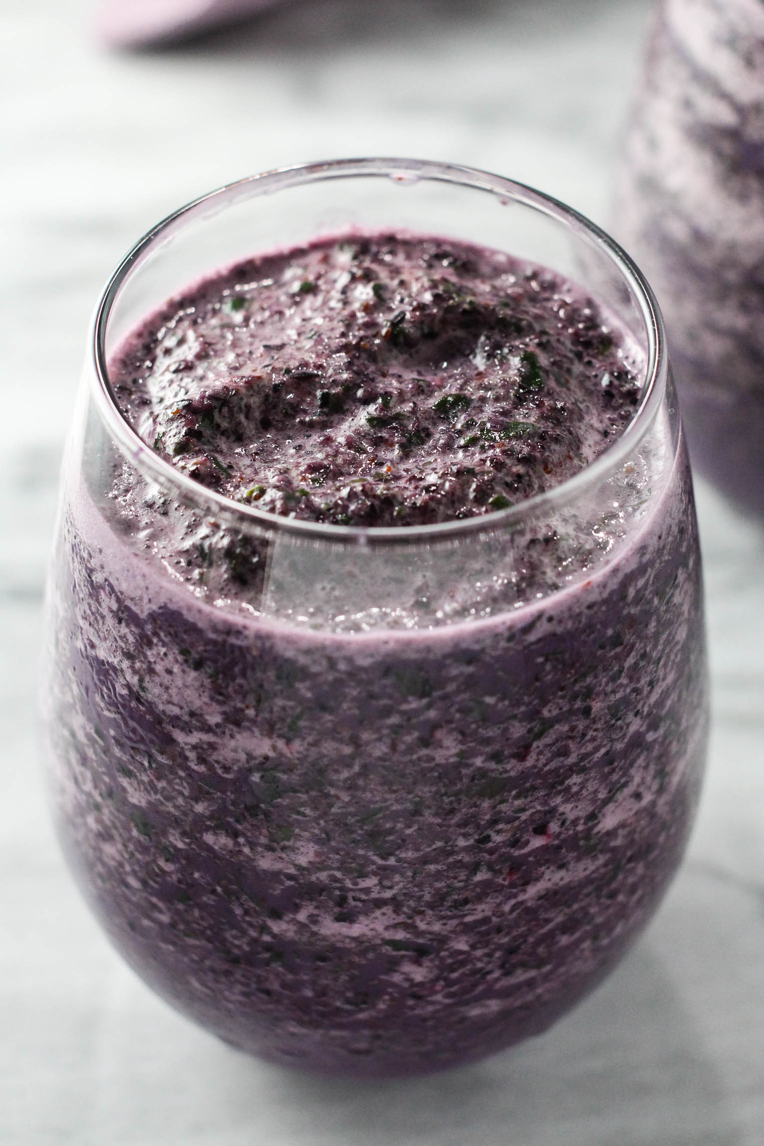 Close up shot of the blueberry kale smoothie in a glass.
