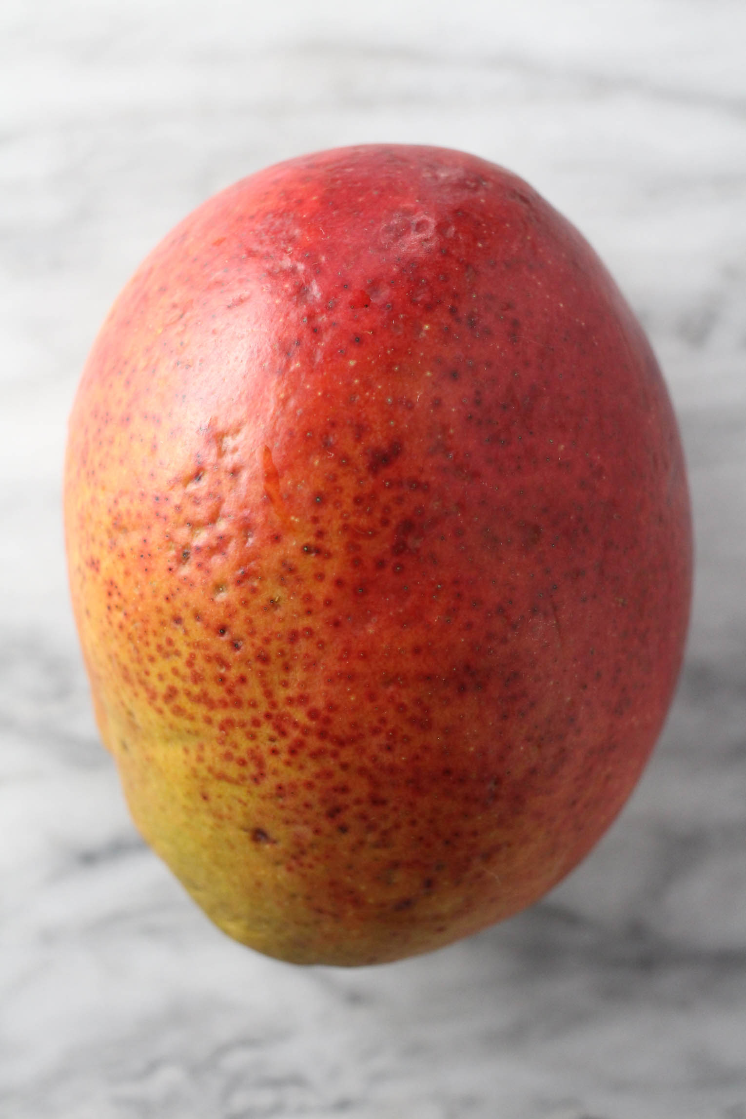 Fresh ripe mango on marble background.