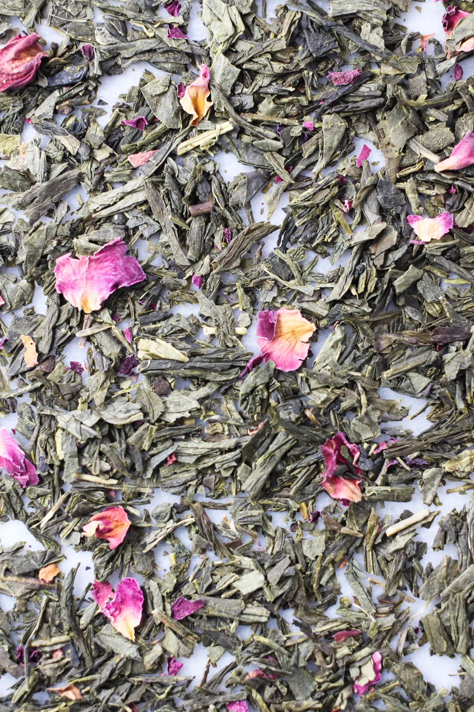 Close up shot of loose green tea with rose petals.