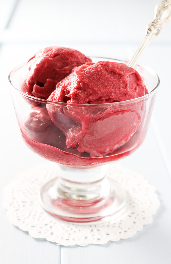 Raspberry ice cream in a glass bowl.