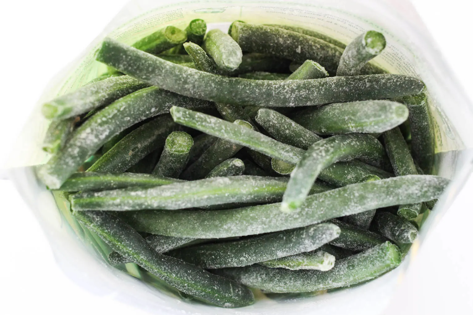 Overhead shot of frozen green beans in a bag.