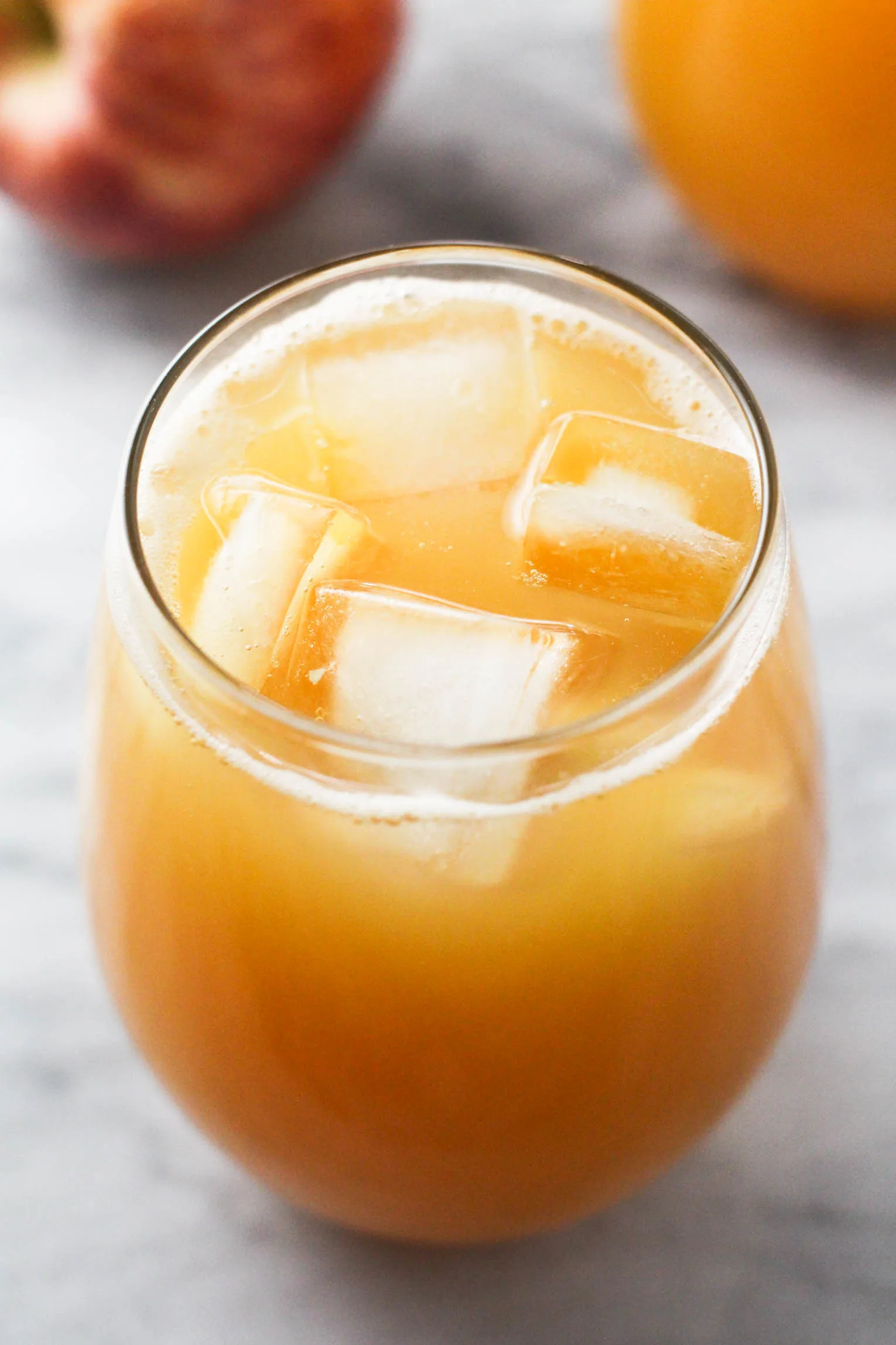 A glass with apple juice with ice cubes. 