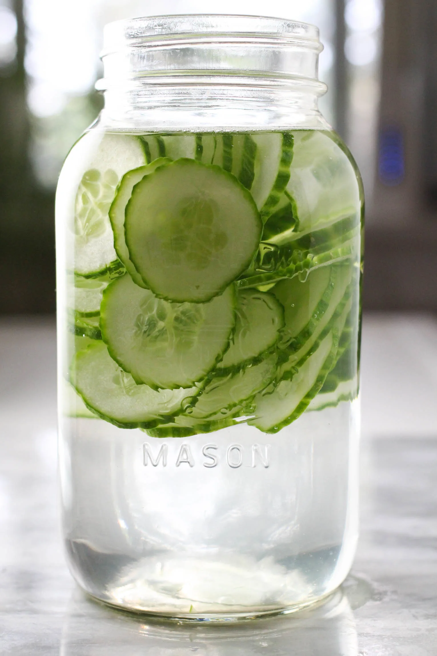 A mason jar filled with water and cucumber slices.