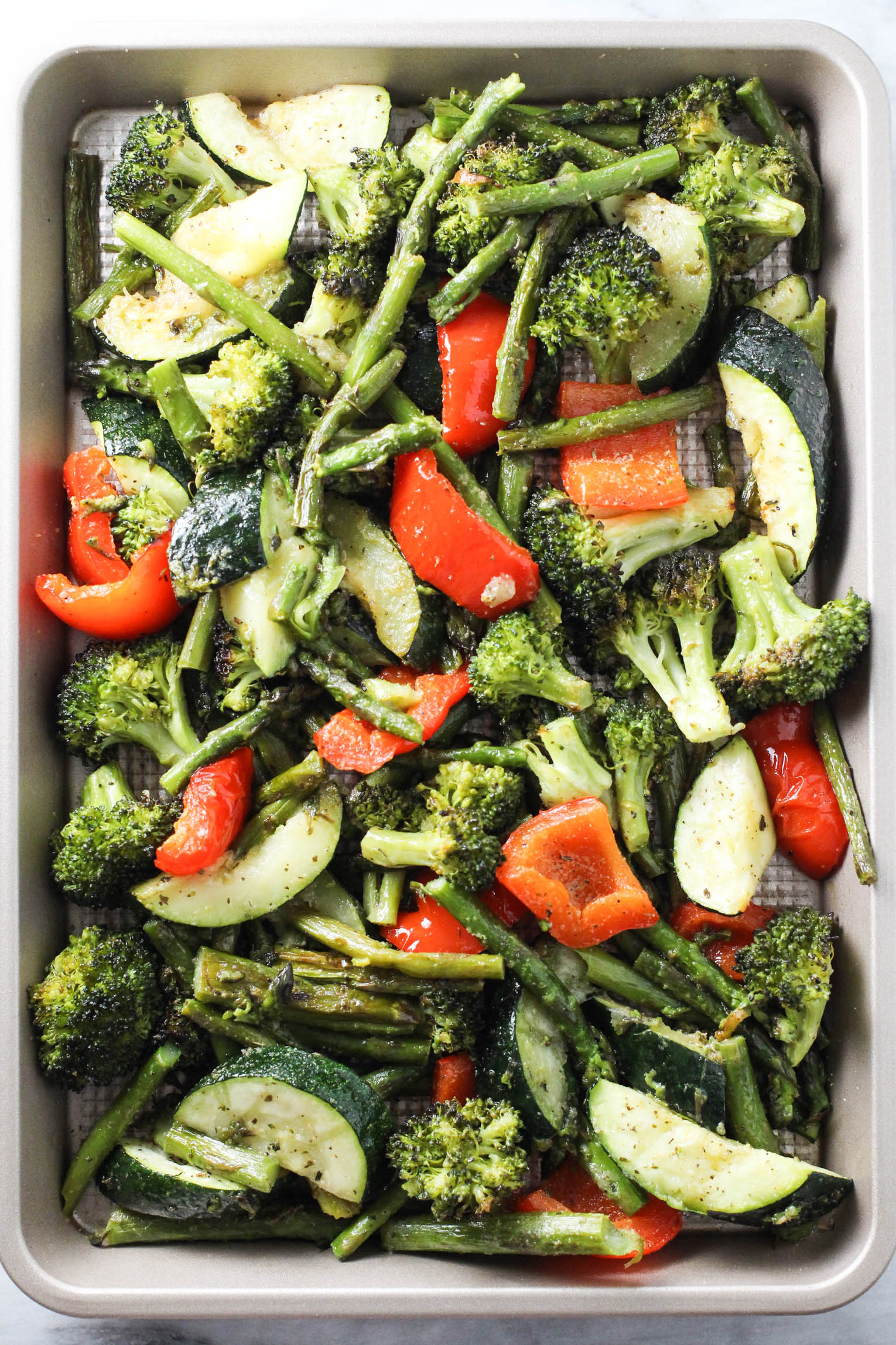 Overhead shot of cooked mixed vegetables on a baking sheet.