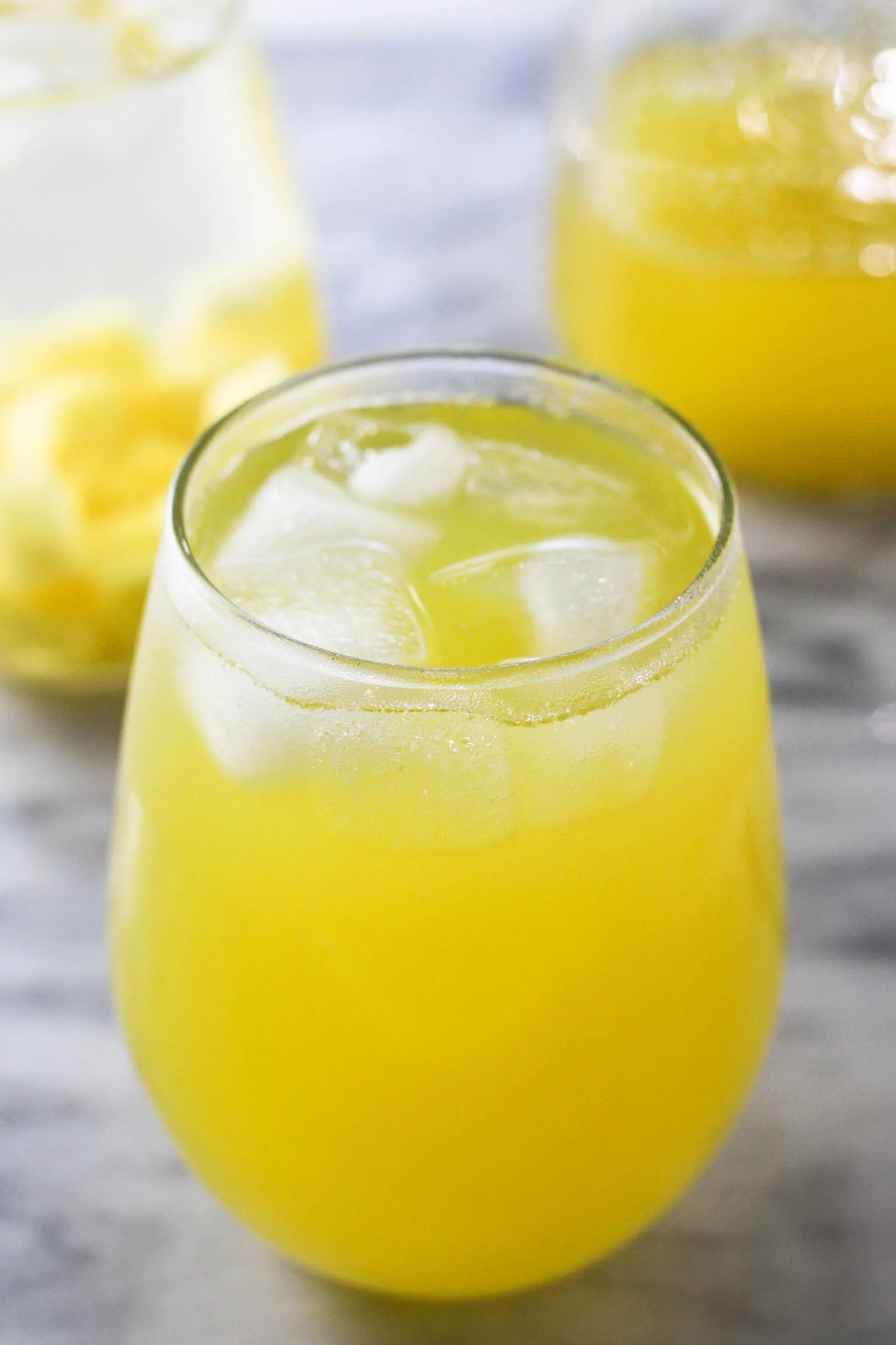 A glass of pineapple water with ice.