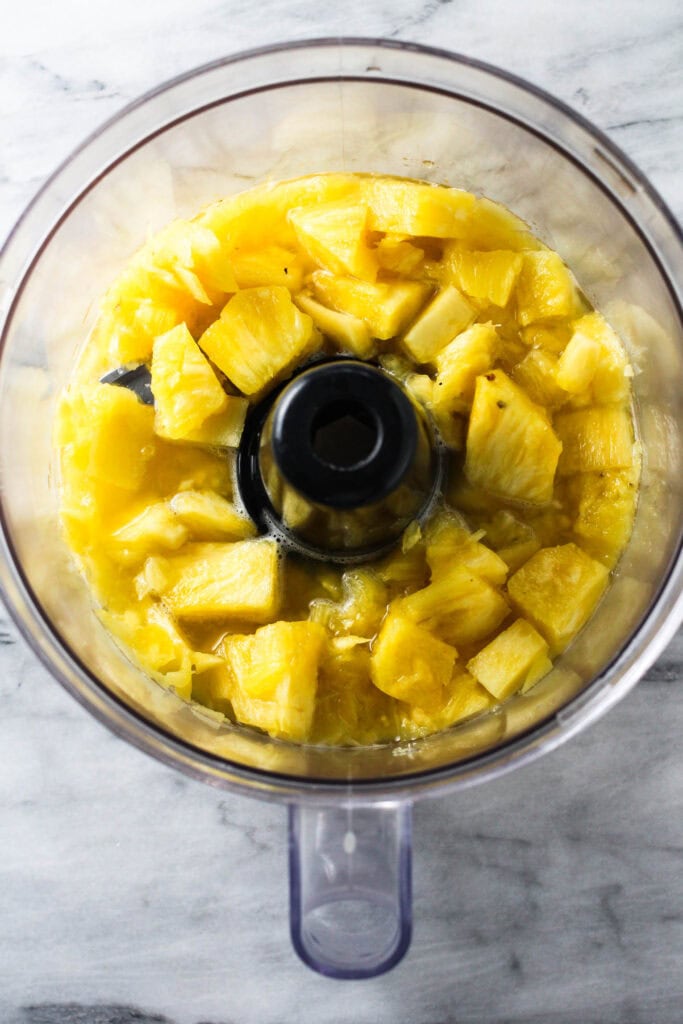 Blending pineapple with water to make juice.