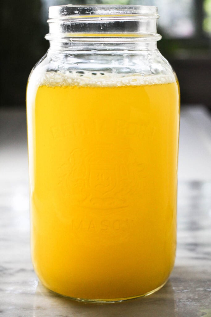 Pineapple juice infused water in a Mason jar.