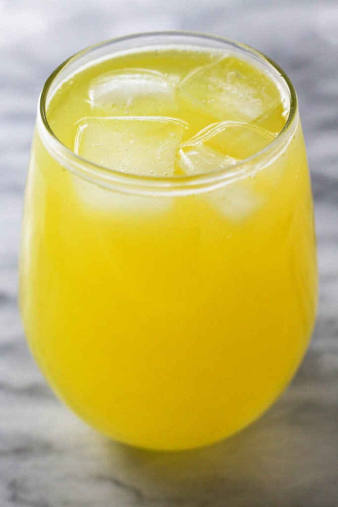 Close-up of pineapple juice infused water with ice cubes in a glass.
