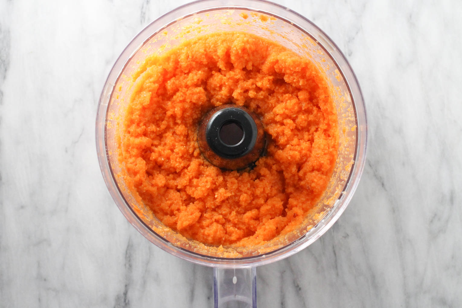 Apple carrot puree in the bowl of food processor.