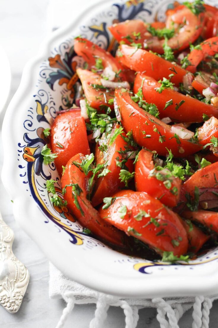 Close up shot of the marinated tomato and onion salad in a bowl.