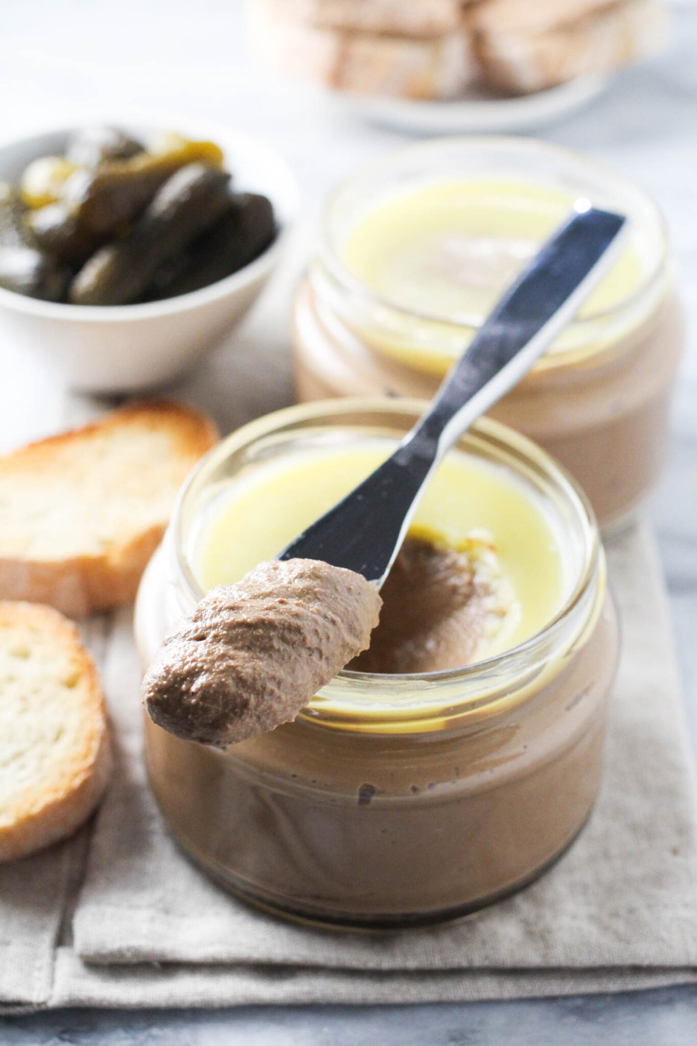 Pashtet in a jar with a flat knife with a bit of pate on top.