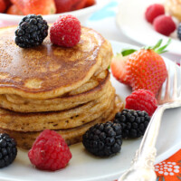 Spelt pancakes garnished with berries on a plate.