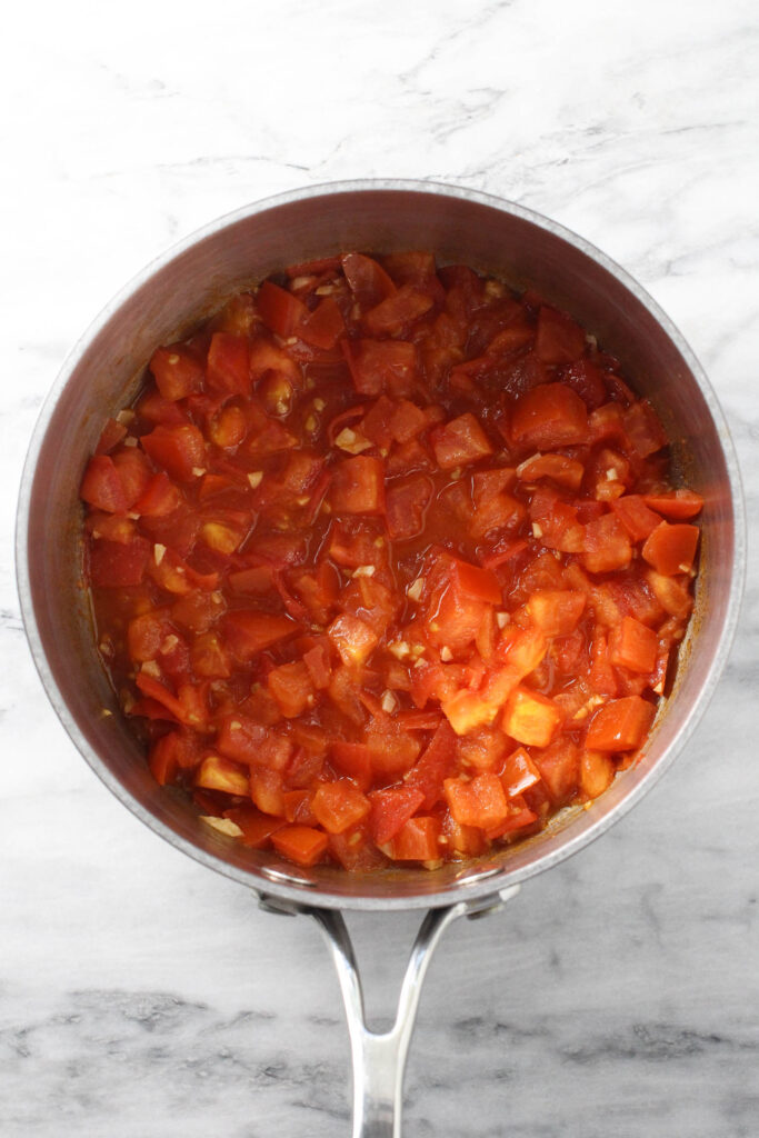 Cooked diced tomatoes in a saucepan.