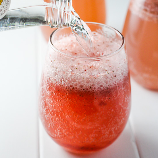 Strawberry soda in a glass on white background.