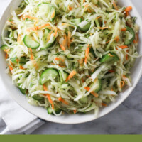 Cabbage cucumber salad on a plate. Below the image, there is a text overlay: green cabbage cucumber salad recipe.