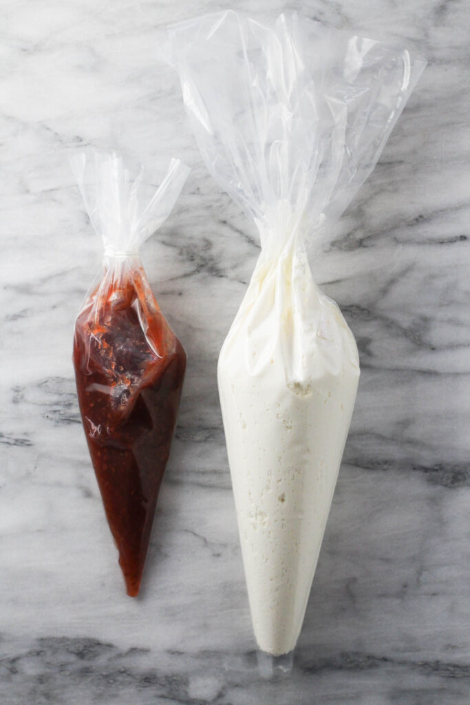 Cheese mixture and raspberry gam in piping bags.