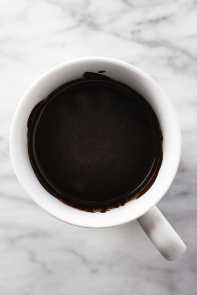 Melted chocolate glaze in a mug.