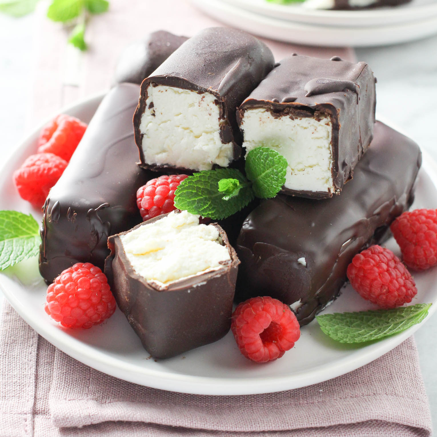 Syrok bars on a plate, garnished with raspberries and mint.