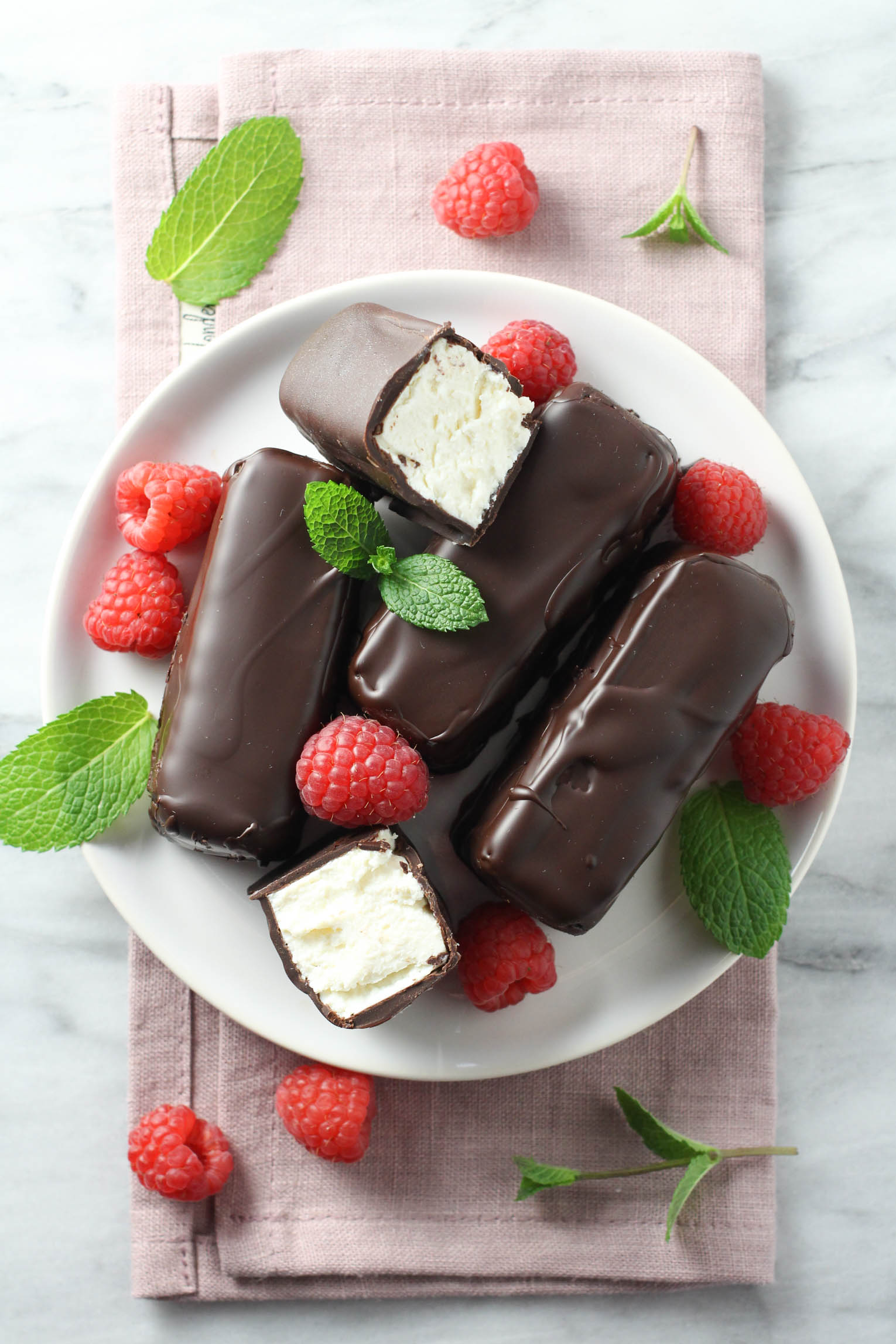 Syrok bars on a plate, garnished with raspberries and fresh mint leaves.