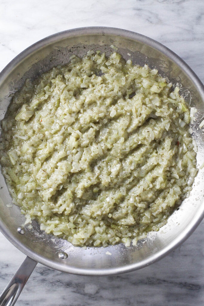 Overhead view of the flour and onion mixture in a frying pan.