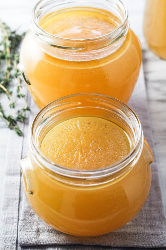Two glass jars with turkey bone broth.