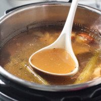Turkey bone broth being ladled out of the Instant Pot.