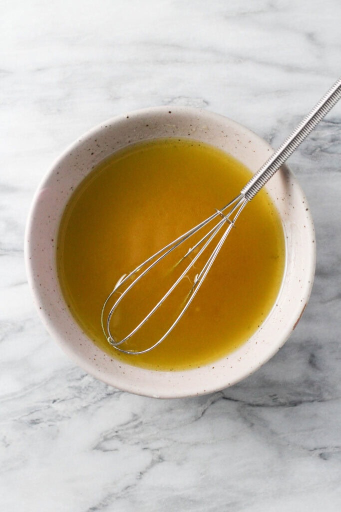 Vinegar and oil dressing for Krautsalat in small bowl.