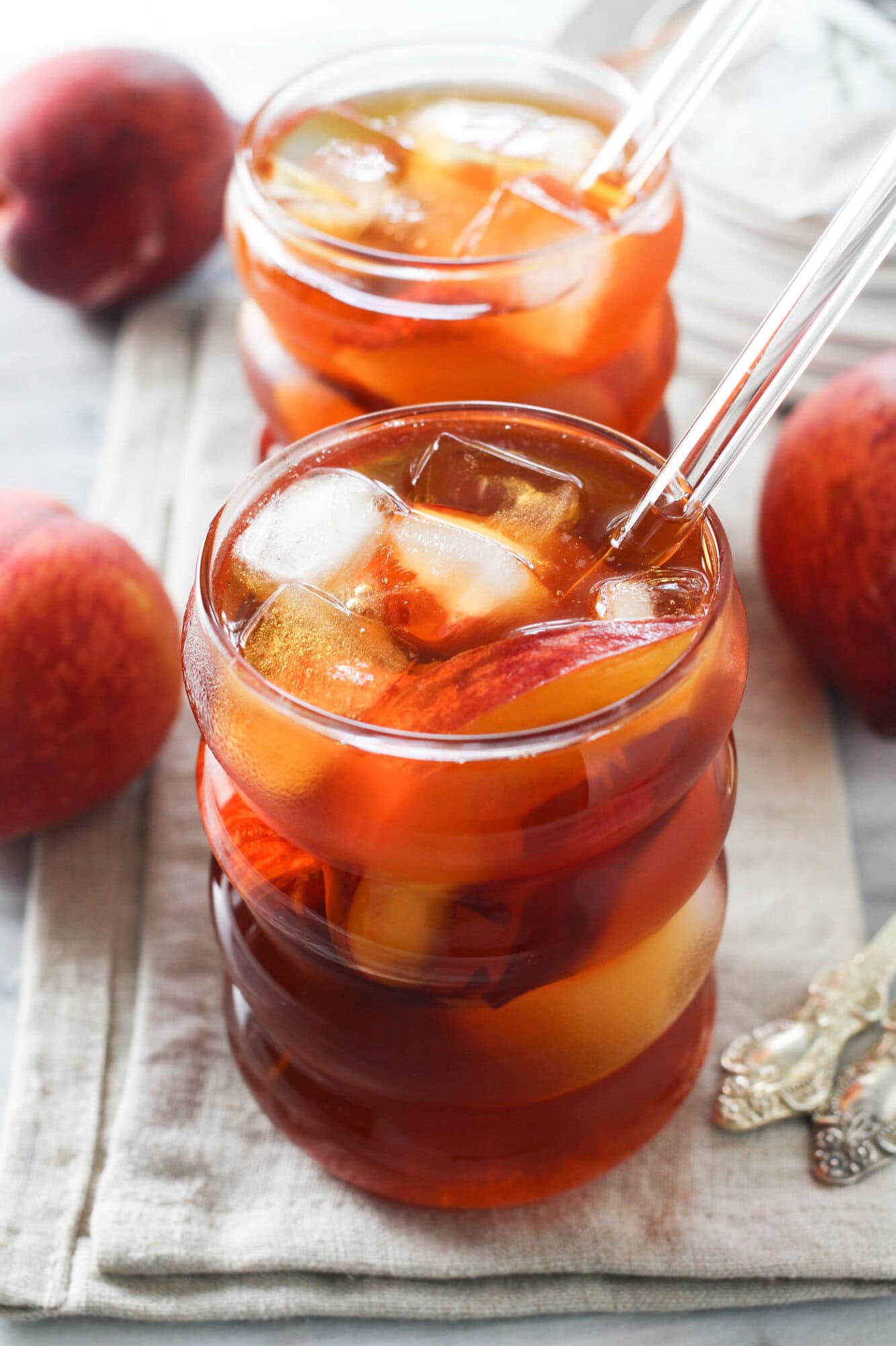 Peach rooibos iced tea served over ice with fresh peach slices.