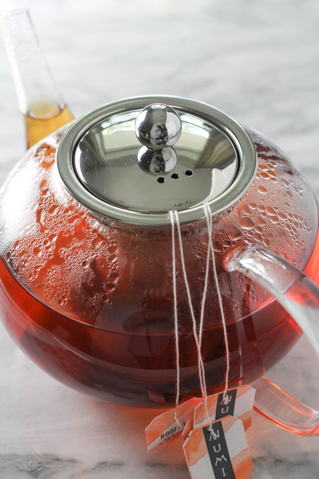 Rooibos tea steeping in a tea pot with hot water.