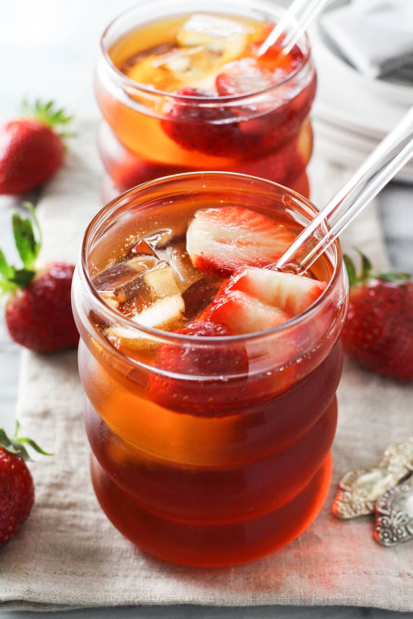 Strawberry rooibos iced tea served over ice with fresh strawberry slices.